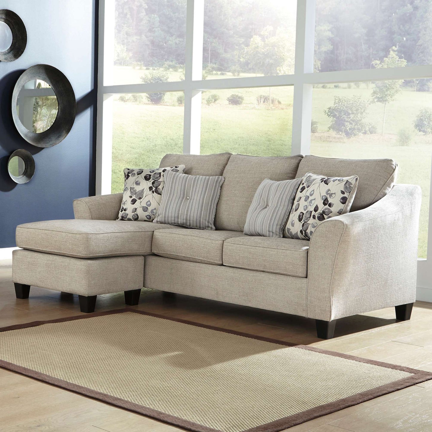 Fava beige sofa with reversible chaise and accent pillows in living room setting