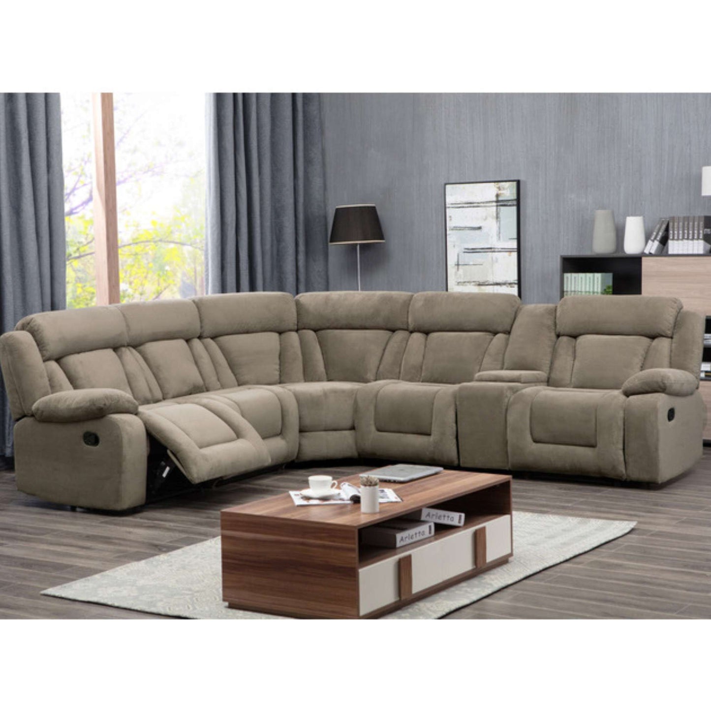 A tan colored 6-piece reclining sectional sofa arranged in a living room setting with a storage console and a wedge ottoman.