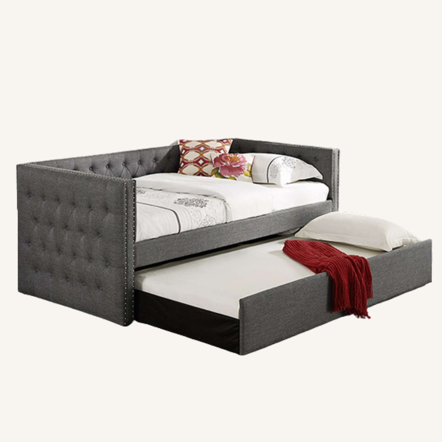 Gray upholstered bed with a pull-out trundle on a white background