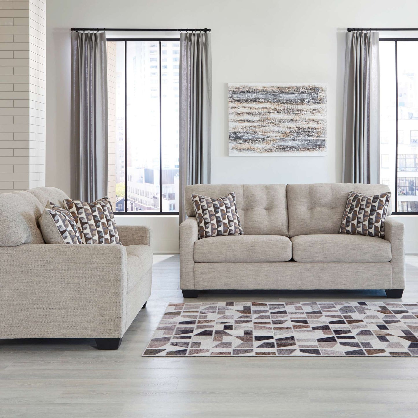 Calbex sofa and loveseat in pebble upholstery with patterned accent pillow in living room setting
