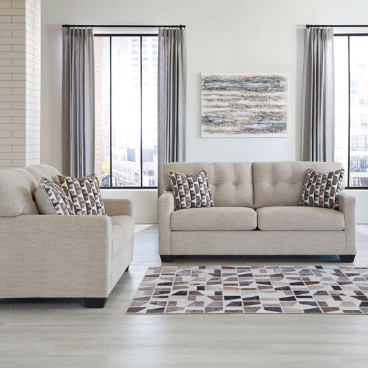 Calbex sofa and loveseat in pebble upholstery with patterned accent pillow in living room setting