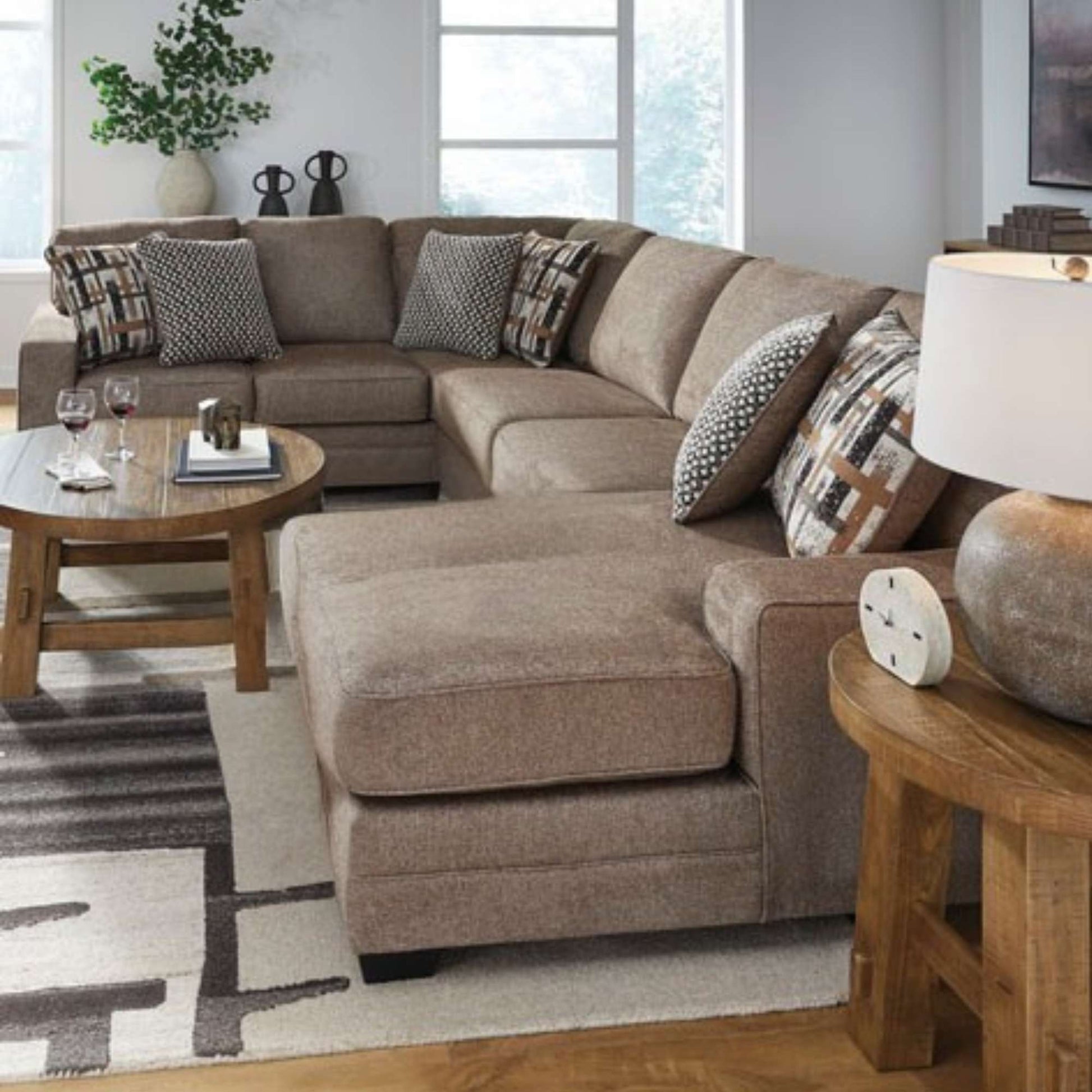 Brown sectional sofa with patterned cushions in a living room setting.