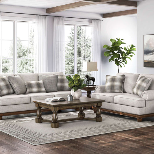 Living room with Dionne sandstone loveseat and sofa set, wooden coffee table, and decorative elements.
