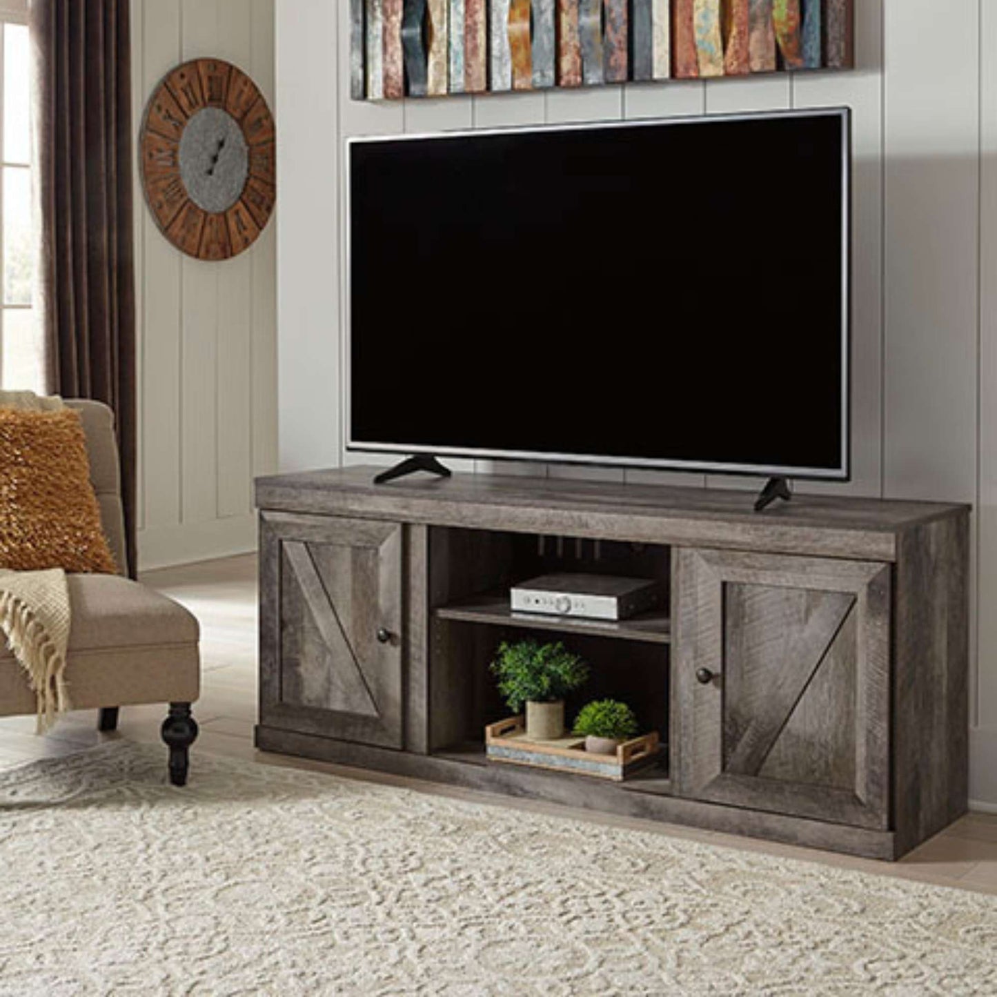 TV on a wooden stand in a living room setting with a clock and decorative items.