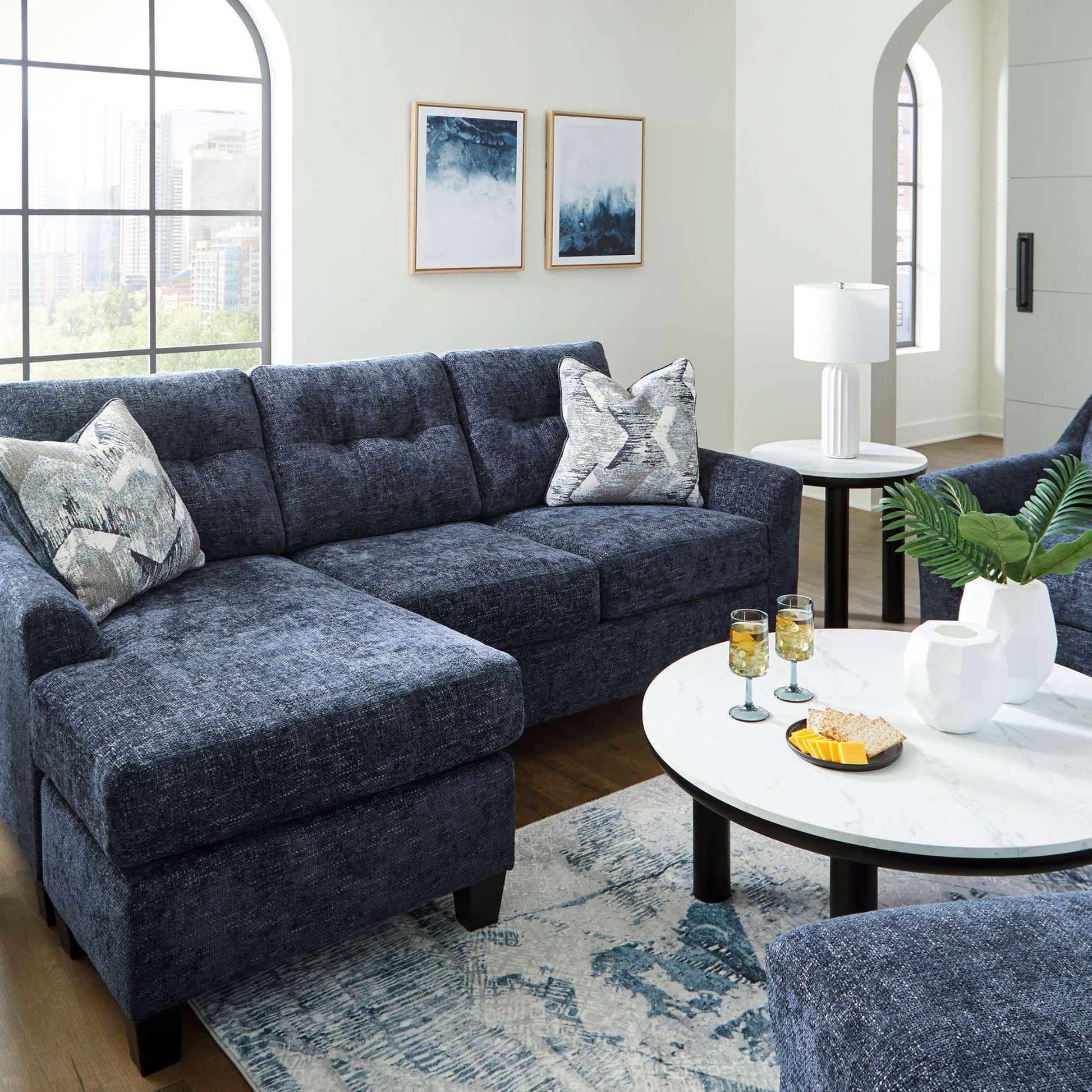 The contemporary Galen sofa chaise available in navy upholstery with accent pillows included in a living room setting
