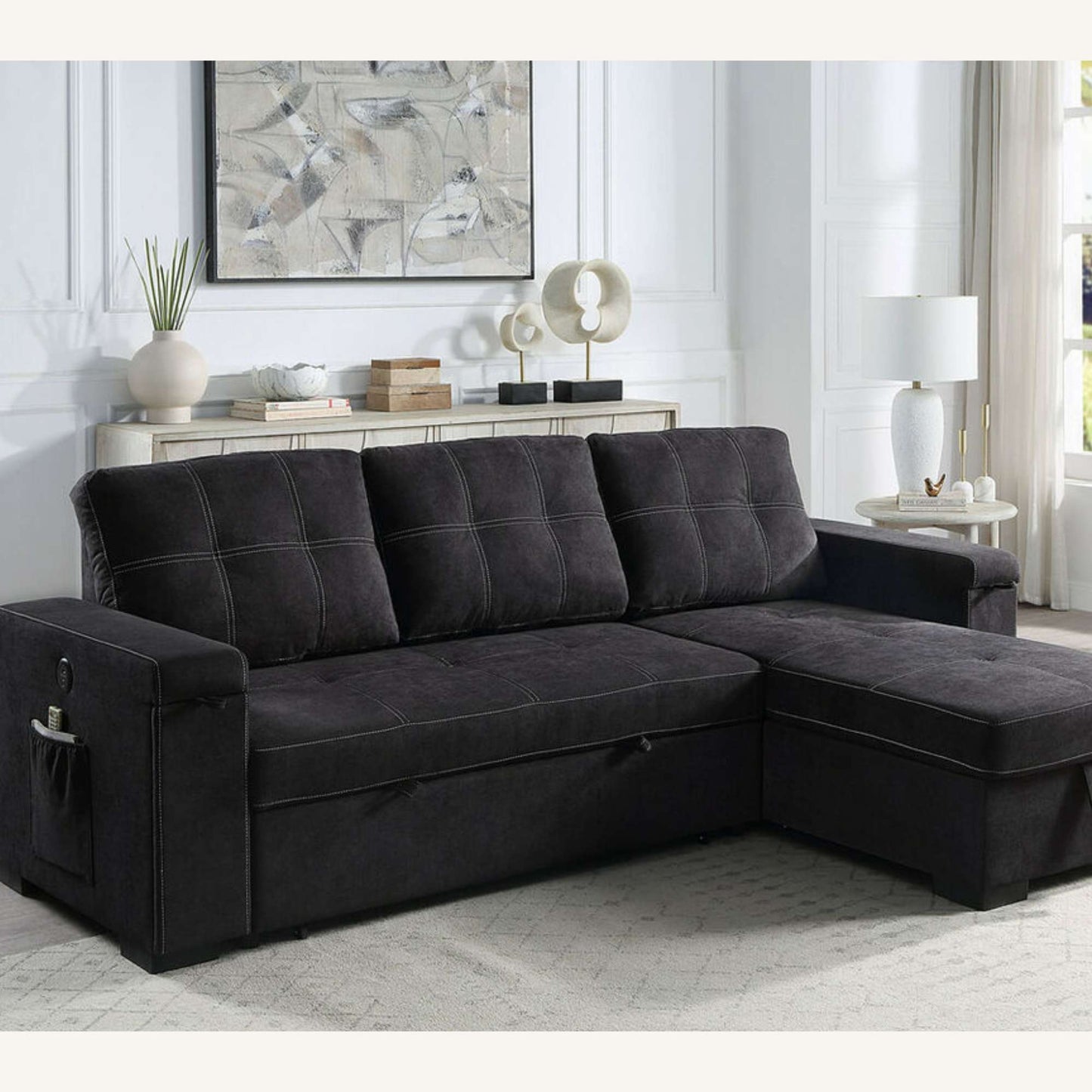 Dark Gray/Black sectional sofa with chaise in a living room setting with decor elements.