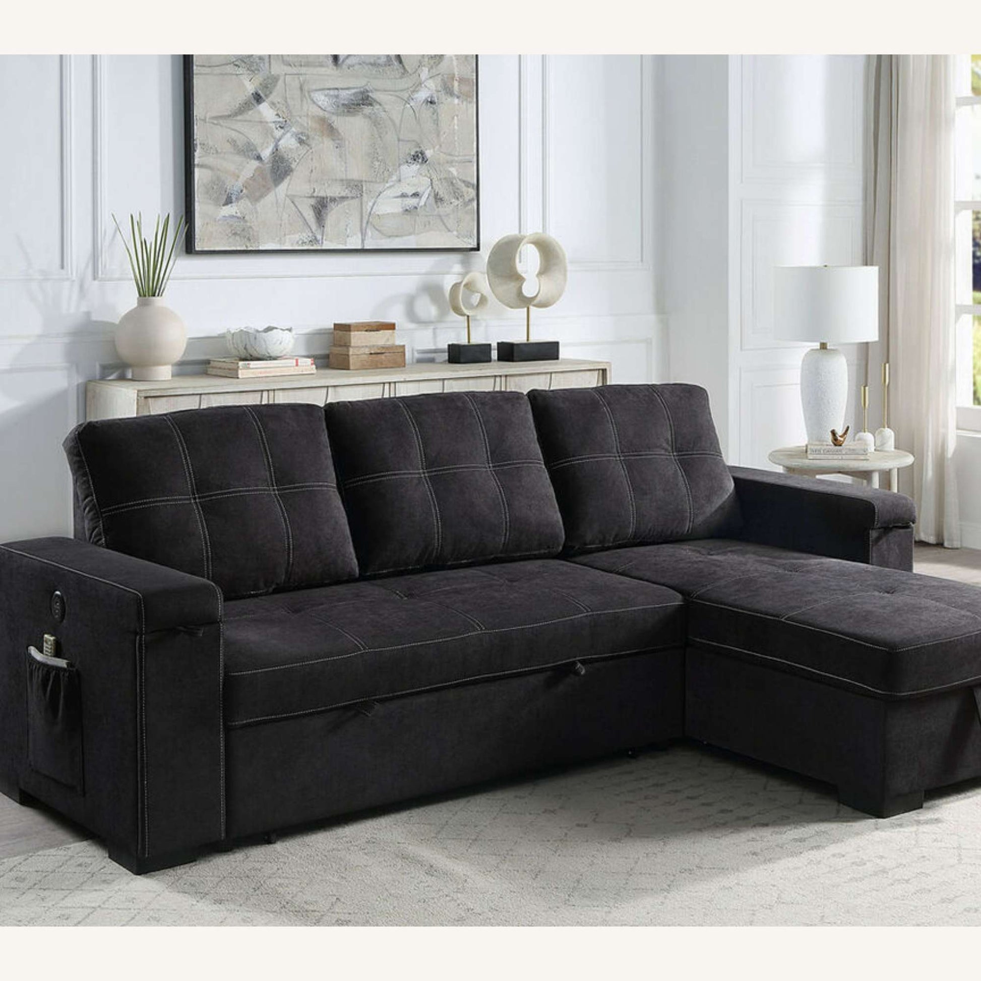 Dark Gray/Black sectional sofa with chaise in a living room setting with decor elements.