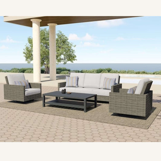 Jedda Outdoor Sofa, two outdoor swivel chairs, and outdoor coffee table in grey in an outdoor patio setting