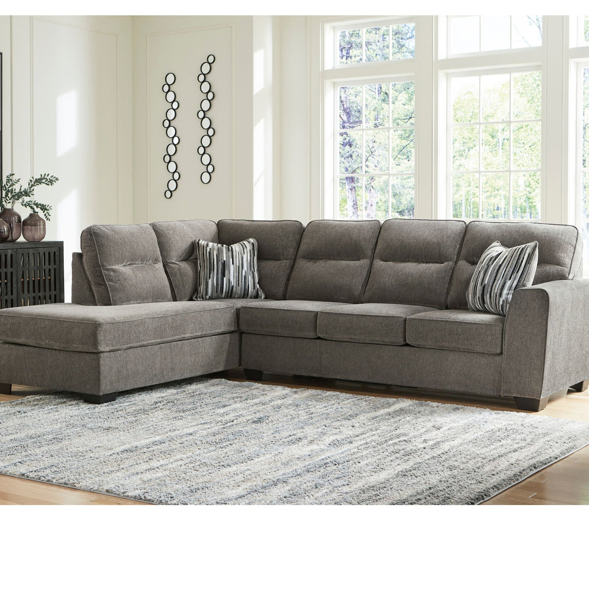 Graphite grey Loxley sectional with left-facing chaise with geometric accent pillows in living room setting 