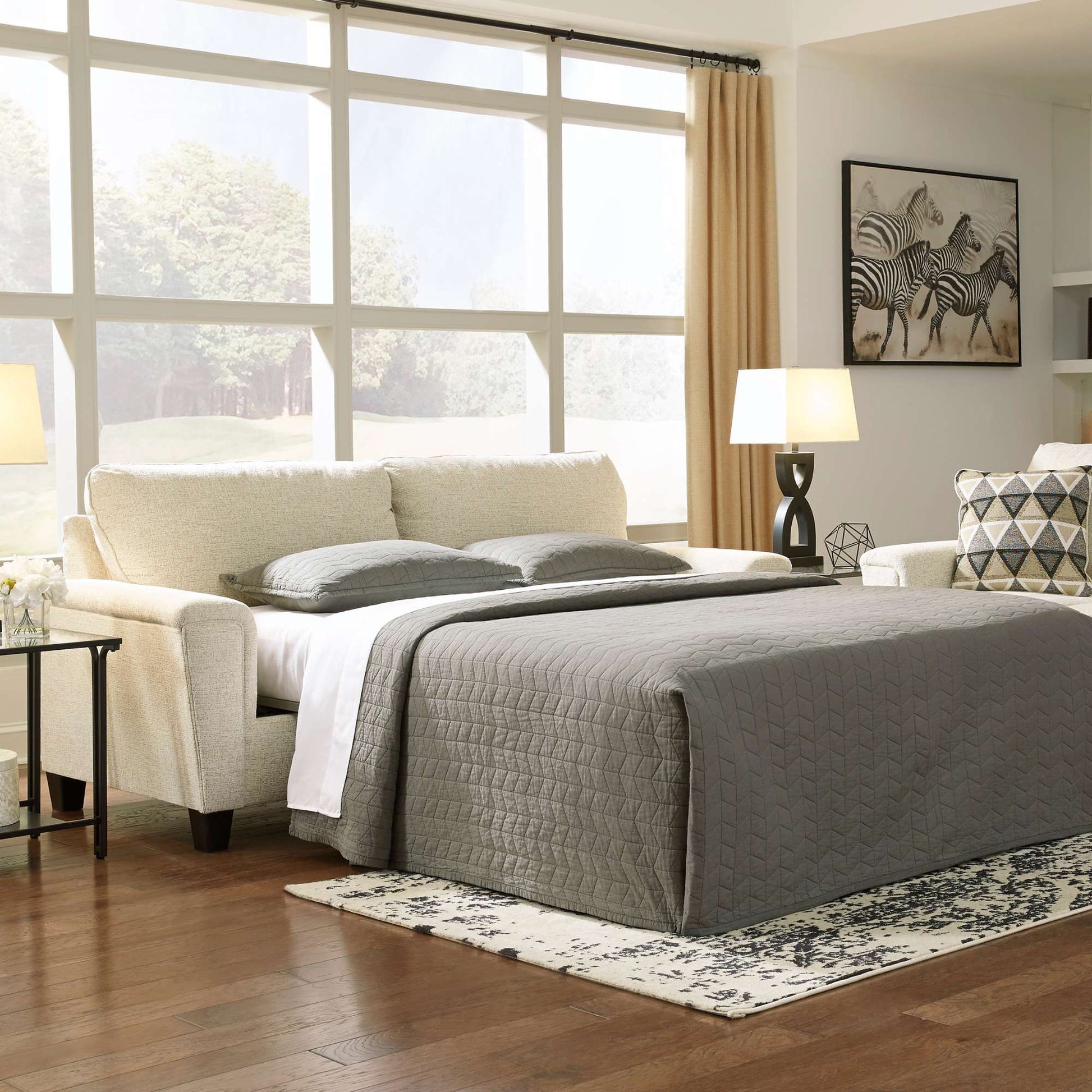 Modern bedroom with a bed, sofa, and large windows.