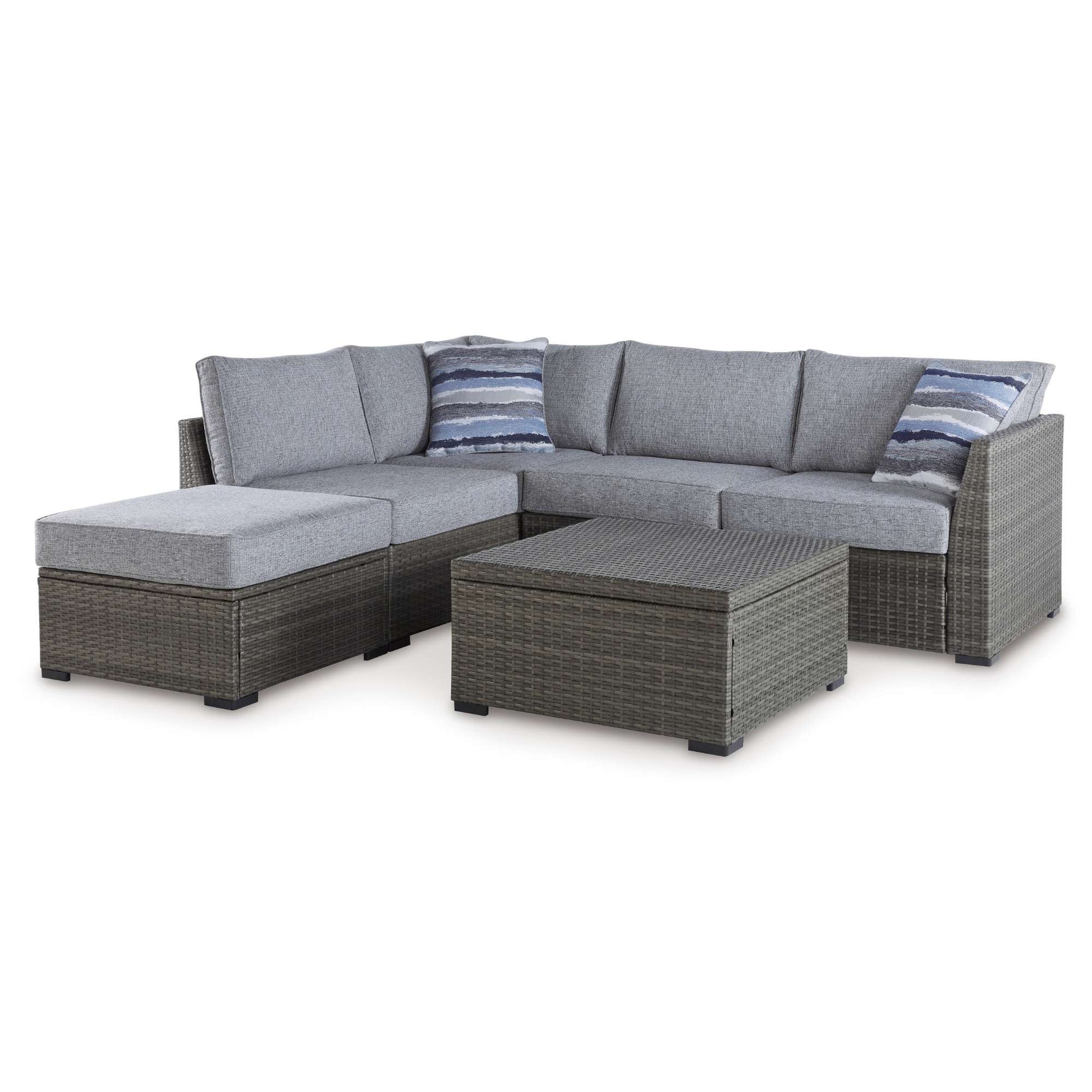 Grey upholstered and grey icker Nolan outdoor sectional with patterned pillows and coffee table on white background