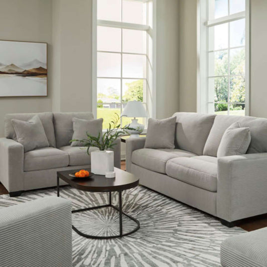 Oakmont sofa and loveseat available in soft corduroy smoke upholstery with accent pillows included displayed in living room setting