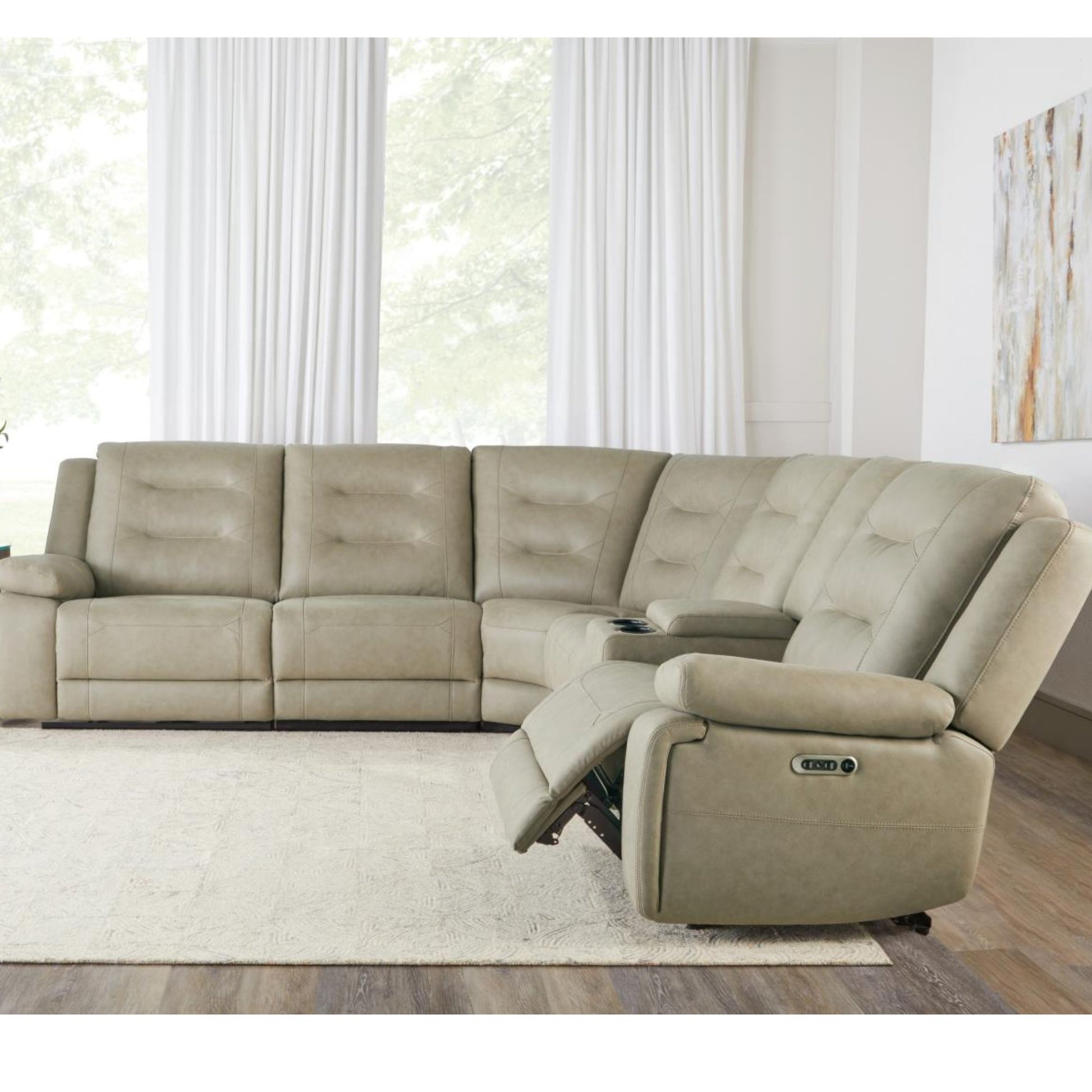 Potrero power sectional in tahoe fog upholstery with tufted cushions and a reclining chaise lounge, shown in a bright living room setting with white curtains and a light rug.