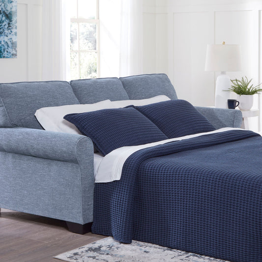 The Rosebury sofa sleeper in denim upholstery with accent pillows with matching blanket and pillows in a living room setting