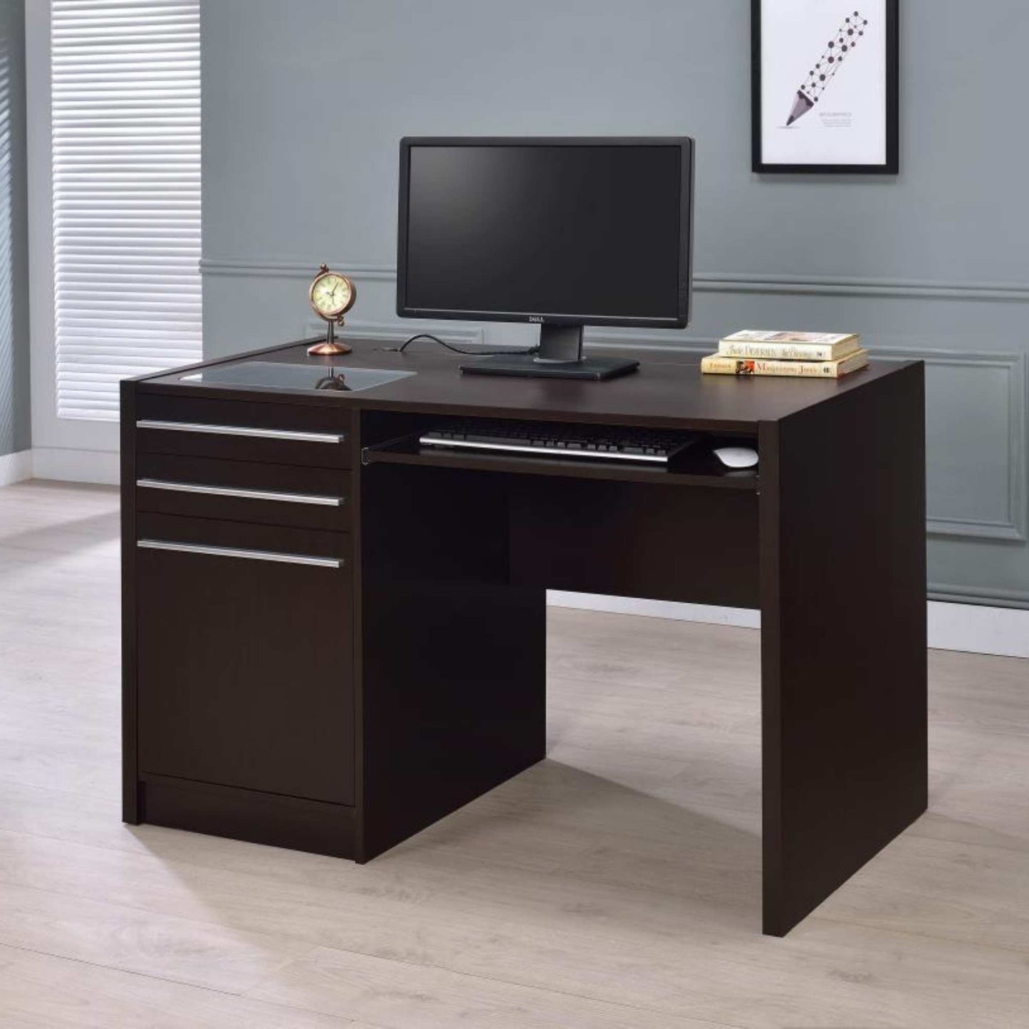 Dark wood L-shaped desk with a computer setup in a room with gray walls and a window.